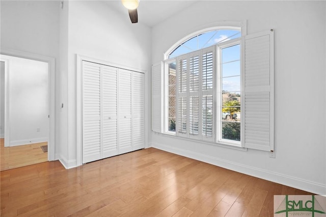 unfurnished bedroom with light hardwood / wood-style floors, a closet, and ceiling fan