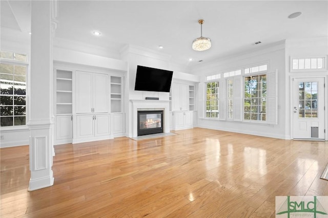 unfurnished living room with light hardwood / wood-style floors, crown molding, and built in features