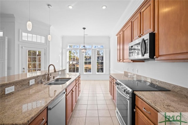 kitchen featuring sink, ornamental molding, light stone counters, appliances with stainless steel finishes, and pendant lighting