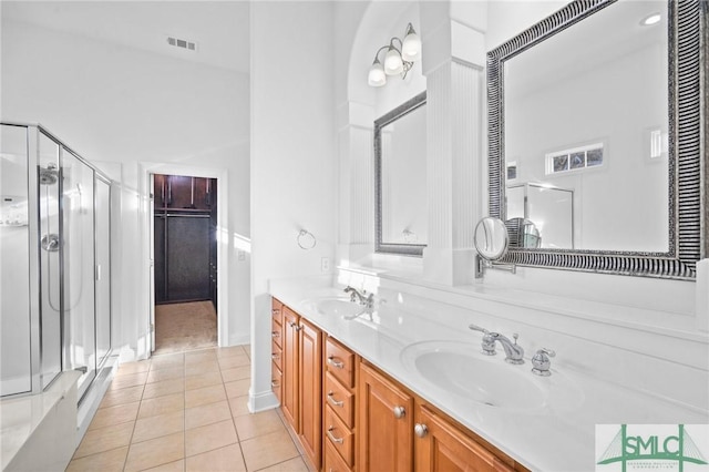 bathroom with tile patterned flooring, vanity, and a shower with door