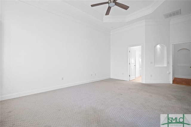 unfurnished bedroom featuring ceiling fan, a tray ceiling, light colored carpet, and ornamental molding