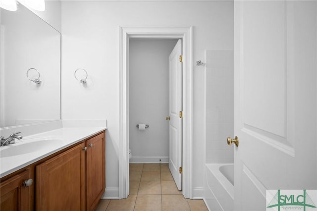 bathroom with a bath, tile patterned flooring, and vanity