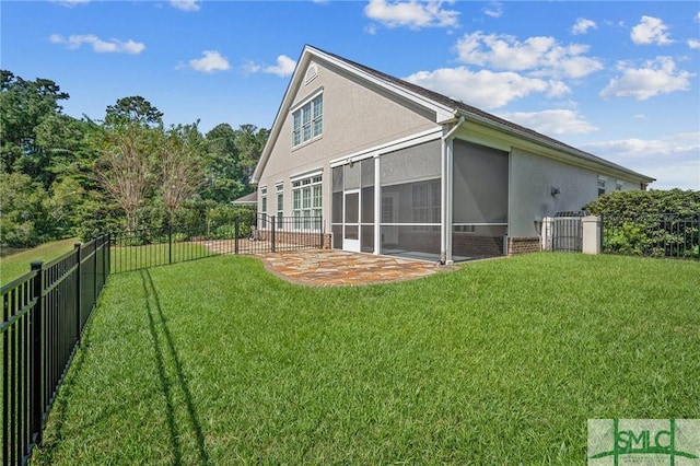 back of house with a sunroom, a patio area, and a lawn