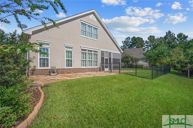 rear view of house with a yard and a sunroom