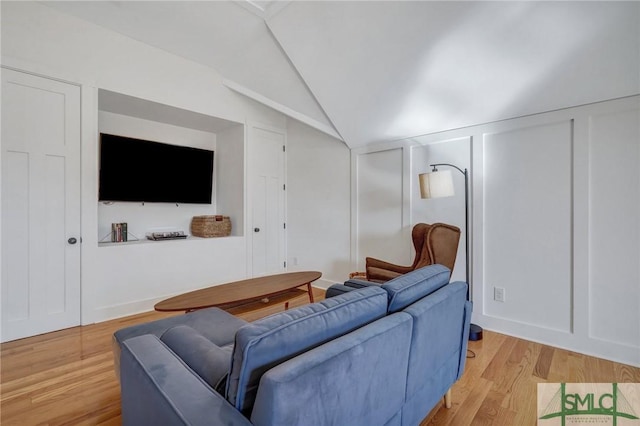 living room featuring lofted ceiling and light wood-type flooring