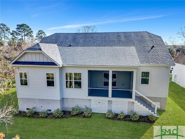 rear view of house with a sunroom and a yard