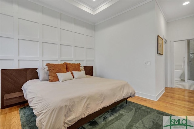 bedroom featuring connected bathroom, crown molding, and wood-type flooring