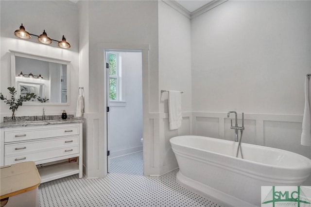 bathroom with vanity, ornamental molding, and a washtub