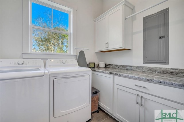 clothes washing area featuring electric panel, cabinets, and washing machine and dryer