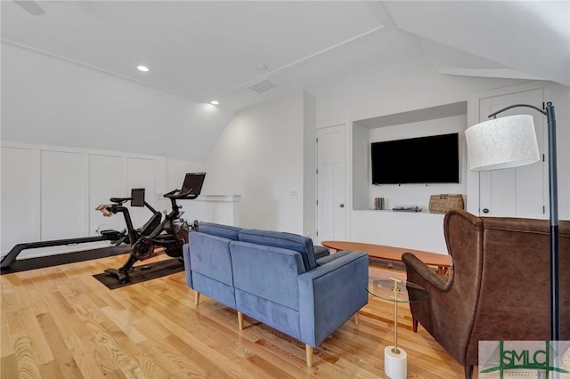 living room featuring lofted ceiling and light hardwood / wood-style floors