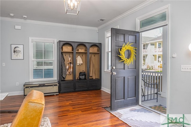 entryway featuring dark hardwood / wood-style flooring, ornamental molding, a wealth of natural light, and a chandelier