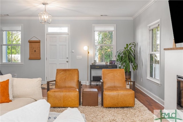 living room featuring hardwood / wood-style floors, ornamental molding, and a notable chandelier