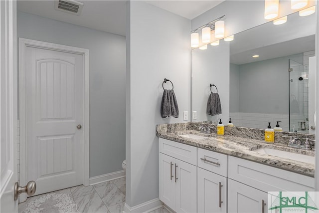 bathroom featuring vanity, toilet, and a shower with shower door