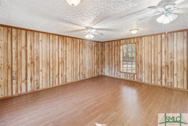 empty room with crown molding, ceiling fan, and hardwood / wood-style flooring