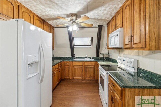 kitchen with ceiling fan, white appliances, sink, and hardwood / wood-style floors