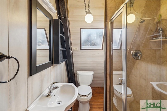 bathroom with an enclosed shower, sink, hardwood / wood-style floors, and toilet