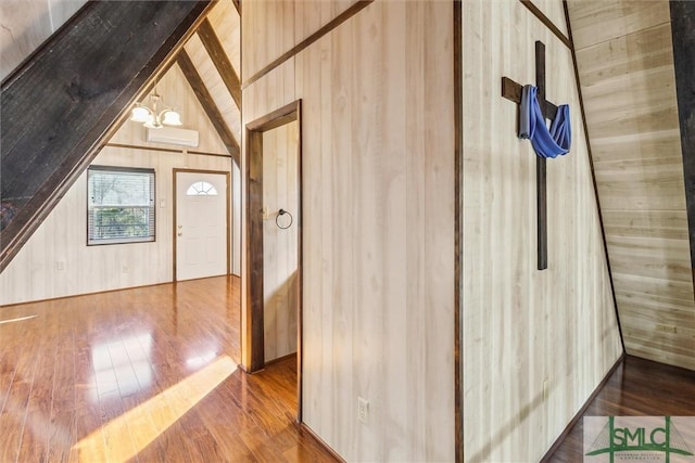 bonus room with hardwood / wood-style flooring, wooden walls, and vaulted ceiling