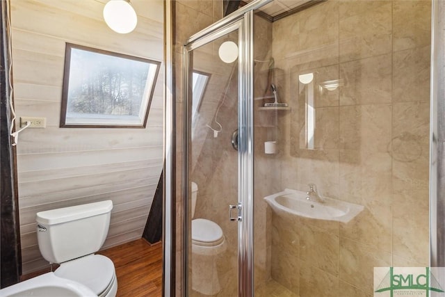 bathroom featuring sink, hardwood / wood-style flooring, a shower with door, and toilet