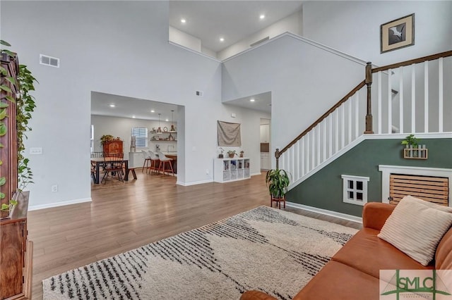 living room with a towering ceiling and hardwood / wood-style flooring