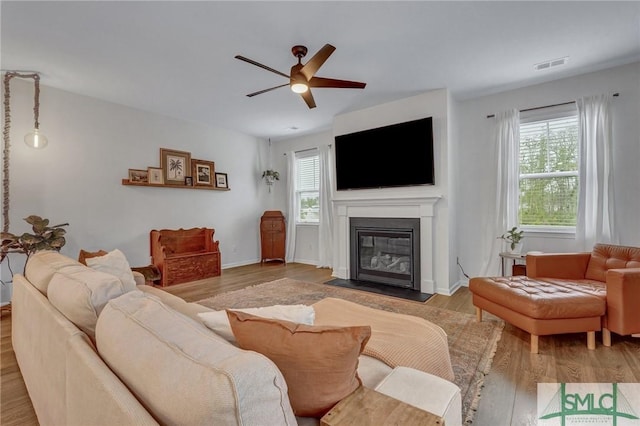 living room with ceiling fan and light wood-type flooring