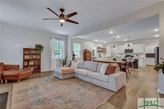 living room featuring light hardwood / wood-style floors and ceiling fan