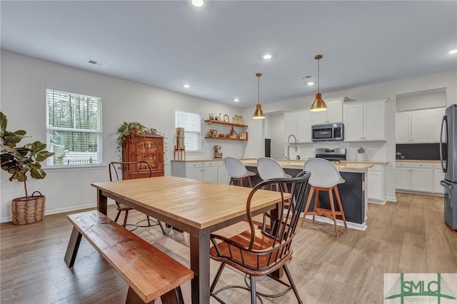 dining area with sink and light hardwood / wood-style flooring