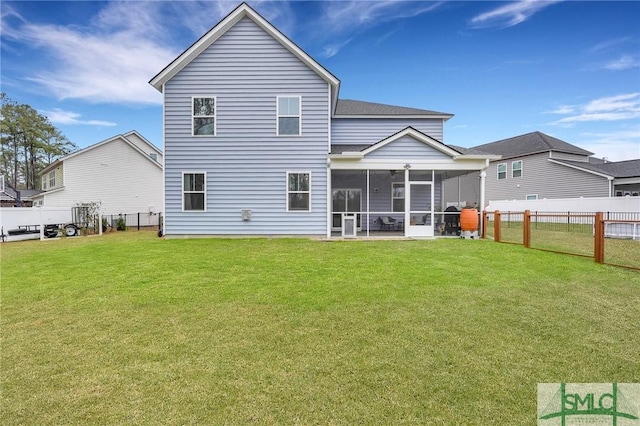 rear view of house with a sunroom and a lawn