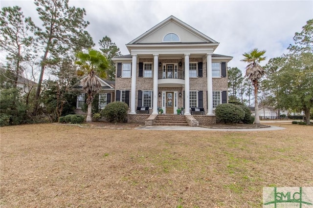 neoclassical home with a balcony and a front lawn