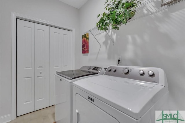 clothes washing area with washer and clothes dryer and light hardwood / wood-style floors