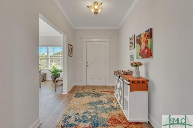 entrance foyer with ornamental molding and light hardwood / wood-style flooring