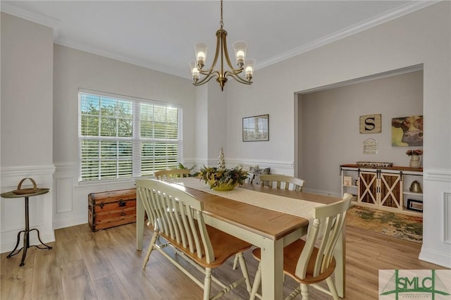 dining space with a chandelier, light hardwood / wood-style floors, and ornamental molding