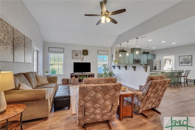 living room featuring light hardwood / wood-style flooring, plenty of natural light, ceiling fan, and lofted ceiling