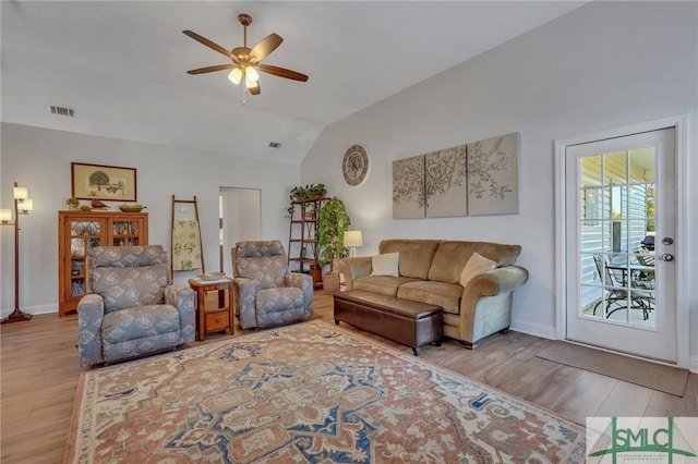 living room with ceiling fan, light hardwood / wood-style floors, and lofted ceiling