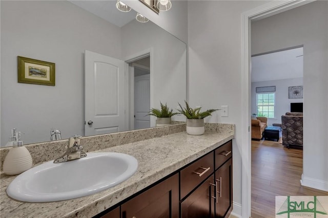 bathroom featuring hardwood / wood-style flooring, vanity, and a notable chandelier