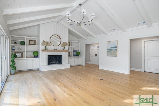 unfurnished living room featuring built in shelves, light hardwood / wood-style flooring, an inviting chandelier, a fireplace, and vaulted ceiling with beams