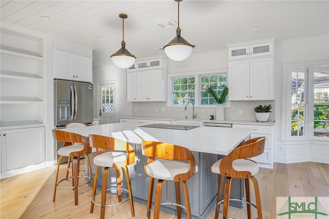 kitchen featuring a center island, white cabinets, pendant lighting, and light hardwood / wood-style flooring