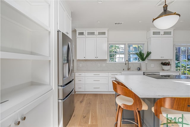 kitchen with tasteful backsplash, pendant lighting, stainless steel fridge with ice dispenser, white cabinetry, and a breakfast bar area