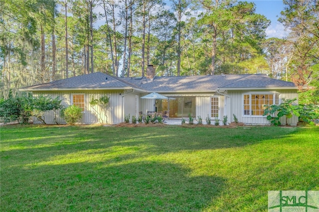 rear view of property featuring a yard