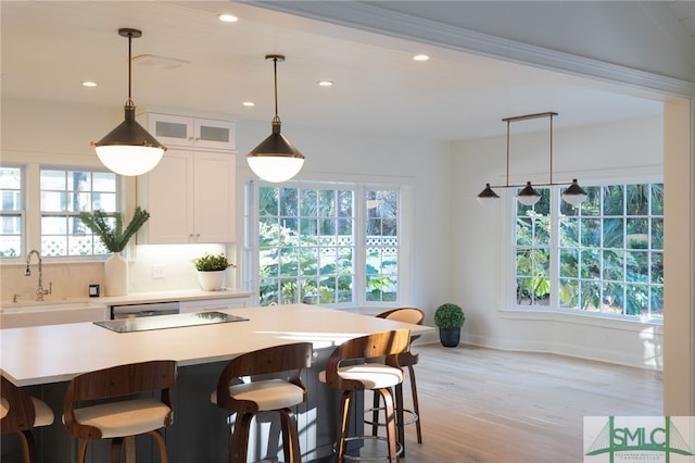 kitchen with white cabinetry, sink, a kitchen island, and plenty of natural light