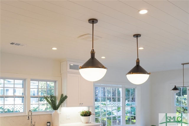 room details featuring white cabinetry and pendant lighting