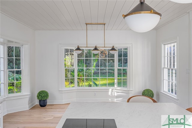 dining space with light hardwood / wood-style flooring and wooden ceiling