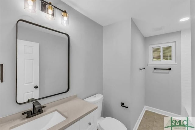 bathroom featuring vanity, tile patterned flooring, and toilet