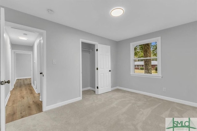 unfurnished bedroom featuring light colored carpet and a closet