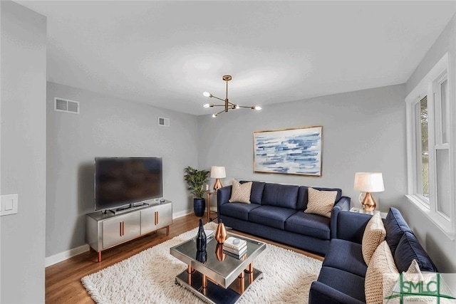 living room featuring wood-type flooring and a notable chandelier