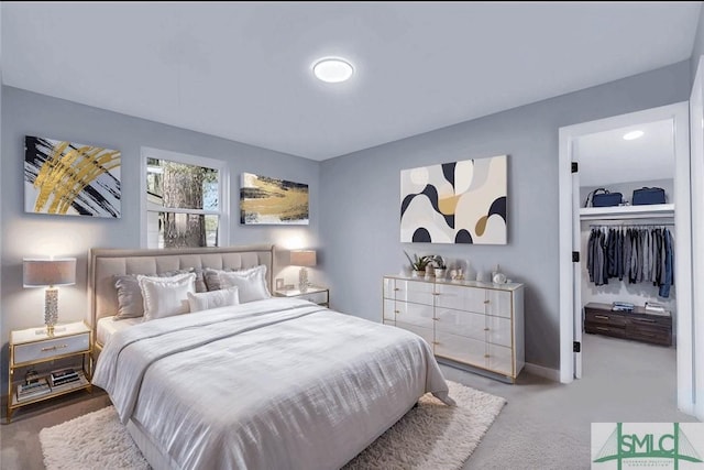 carpeted bedroom with a spacious closet and a closet