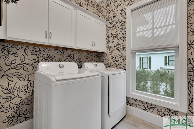 washroom featuring washing machine and clothes dryer and cabinets