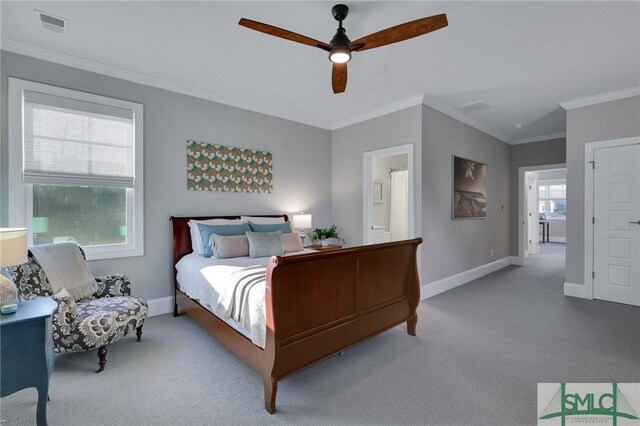 carpeted bedroom with ensuite bath, ceiling fan, and crown molding