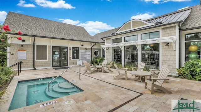 rear view of property featuring a community hot tub and a patio