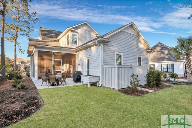 back of house with a patio area, a sunroom, and a yard