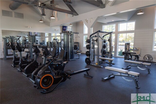 gym with ceiling fan and high vaulted ceiling